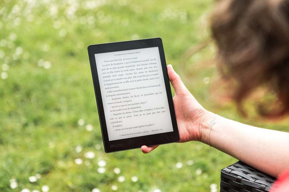 kobieta w ogrodzie trzymająca w ręku czytnik e-booków