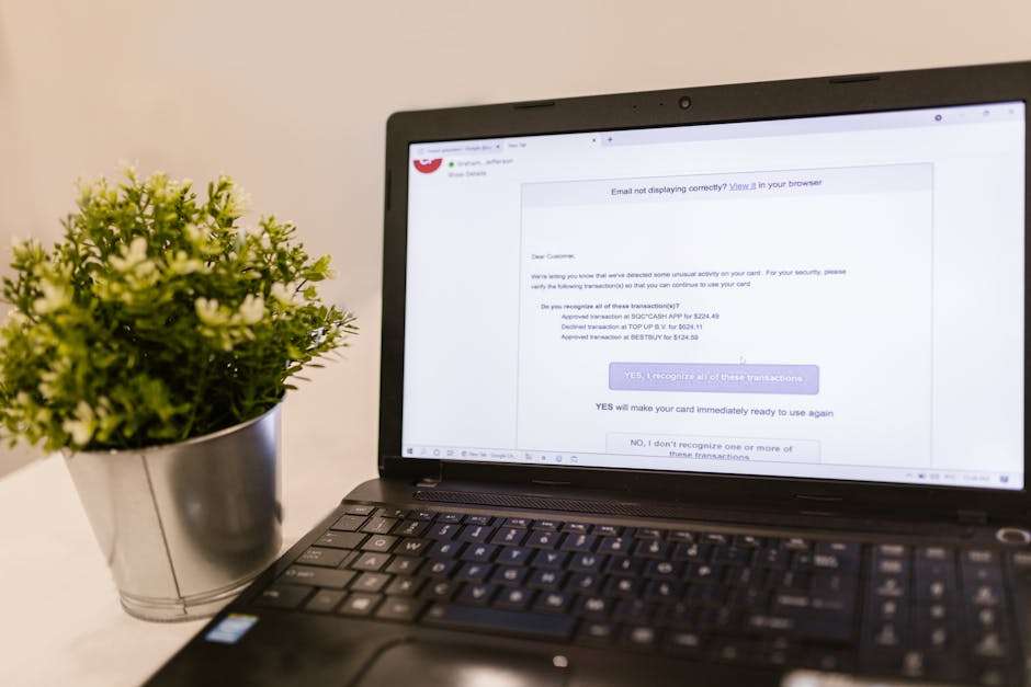 Otwarty laptop z e-mailem o nieautoryzowanych transakcjach na karcie płatniczej.