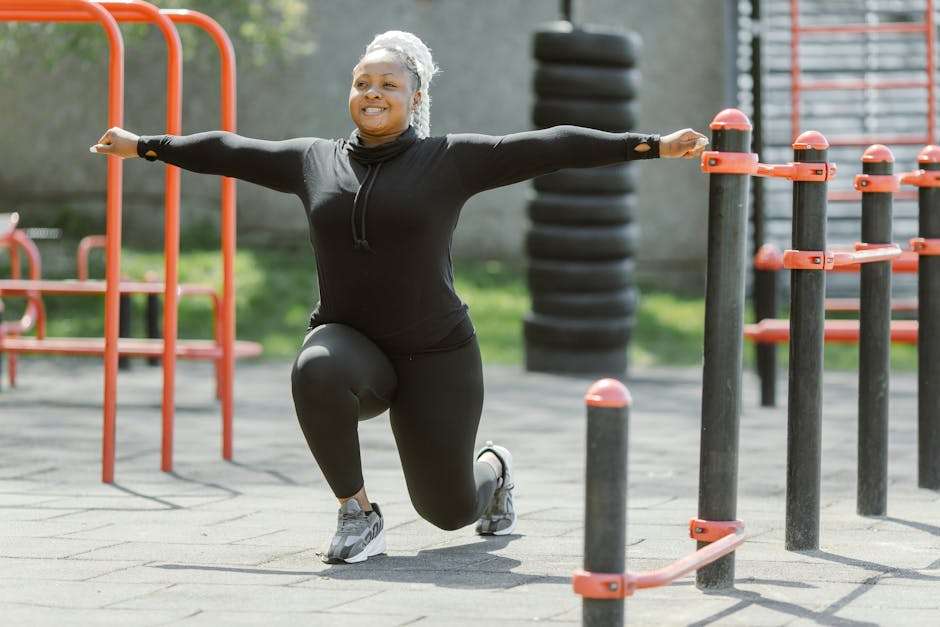 Kobieta w czarnym stroju sportowym wykonuje wypad na zewnątrz na siłowni.